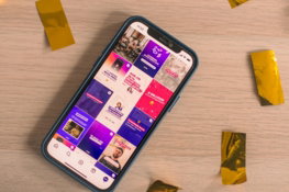a-phone-displays-a-colorful-social-media-feed-.jpg A phone displays a colorful social media feed.